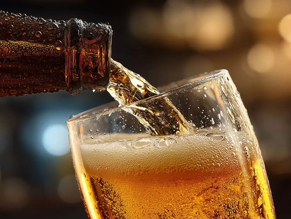 Sprudelndes Bier wird in ein Glas eingeschenkt.